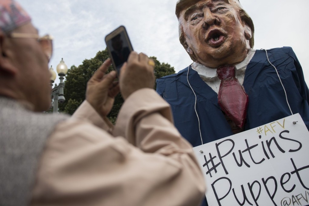 A man takes a photo of a US President Donald Trump puppet during a rally calling for accountability in Washington, DC. Photo: AFP