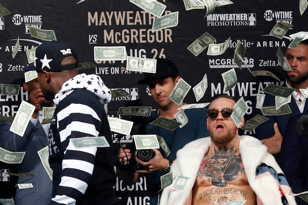 Floyd Mayweather throws money at Conor McGregor during a world tour press conference in Brooklyn to promote their bout. Photo: USA Today