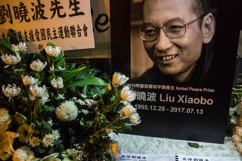 A condolence book is displayed among flowers and a portrait of Liu Xiaobo, at a makeshift memorial in tribute to the late Nobel laureate outside the central government’s liaison office in Hong Kong, on July 13. Photo: AFP