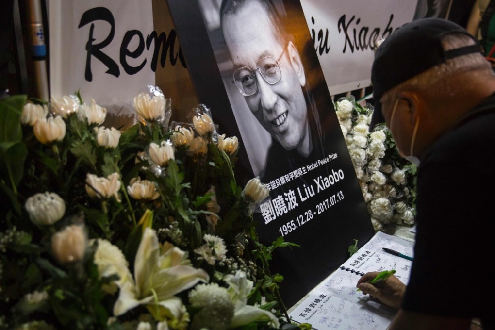 A man writes a message at a makeshift memorial in tribute to late Chinese Nobel laureate Liu Xiaobo, outside the Chinese Liason Office in Hong Kong on Thursday. Photo: AFP