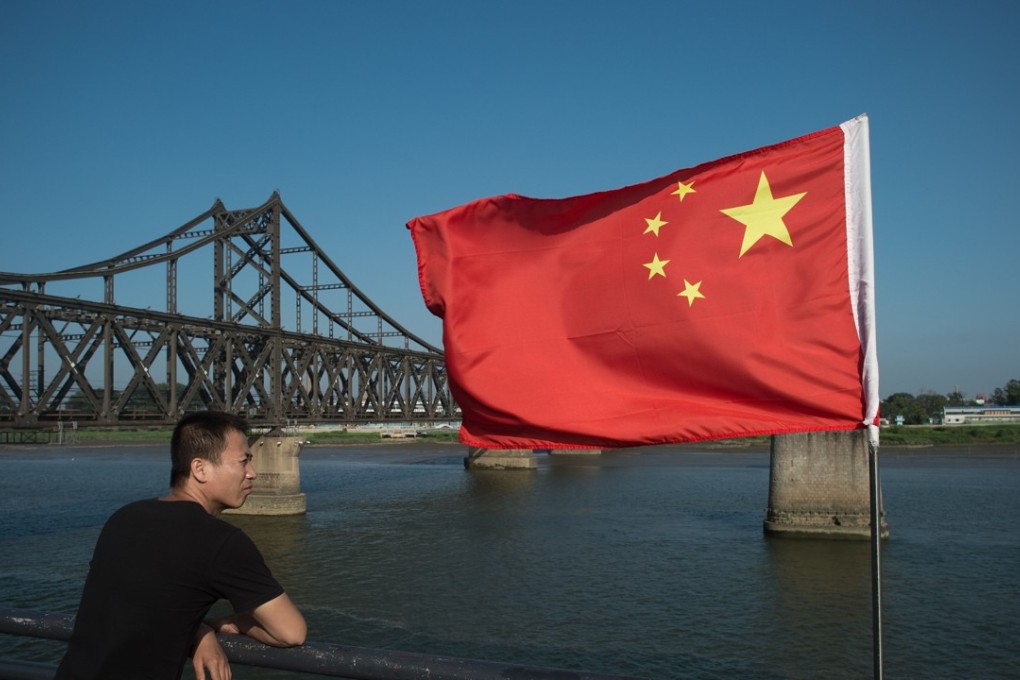 A tourist looking across the Yalu River from China to North Korea. Smaller Chinese companies doing business in North Korea may be targeted in the latest US drafted sanctions. Photo: AFP