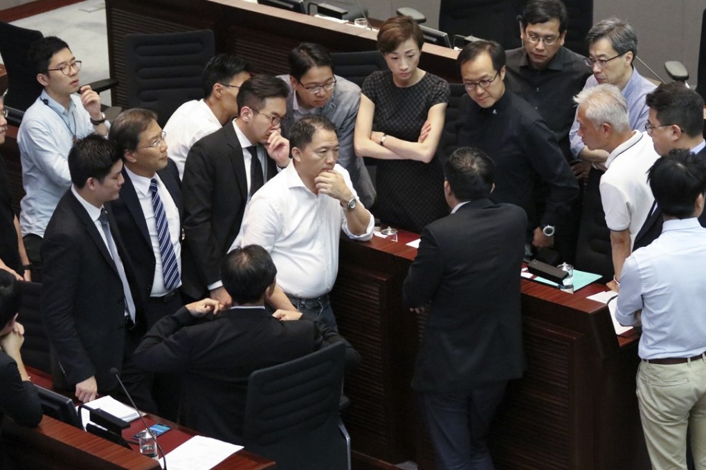 Pan-democrats discuss how to proceed at yesterday’s Legco meeting following the disqualification of four of their lawmakers. Photo: Felix Wong