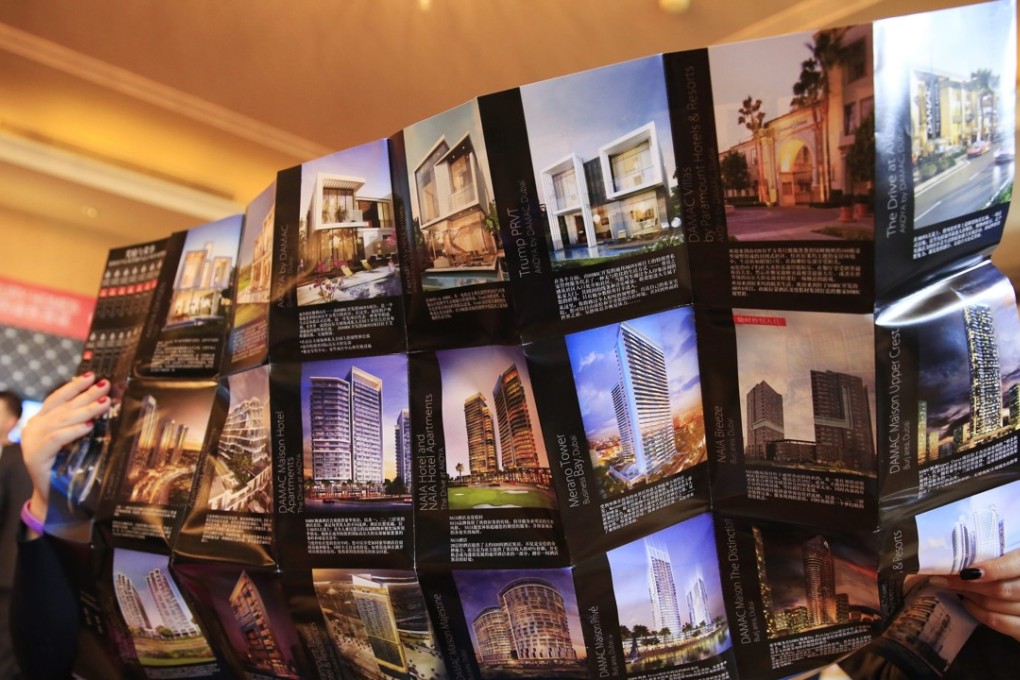 Visitors look at a brochure of luxury properties at a marketing event in Beijing, in this file photo from April last year. Photo: EPA
