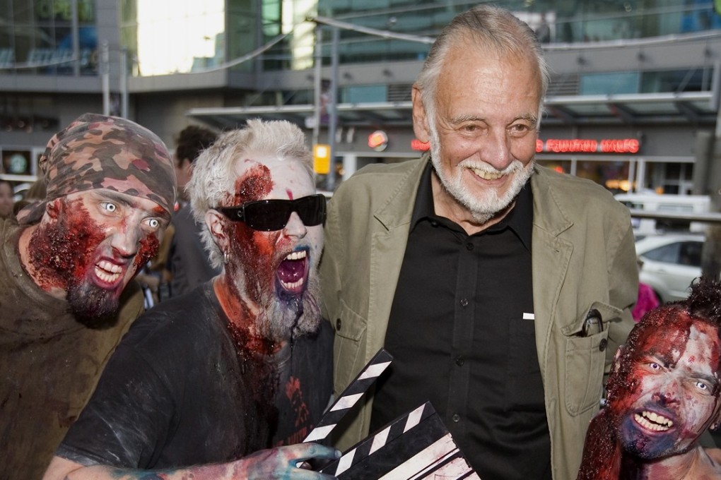 In this September 12, 2009, file photo, director George Romero poses with fans dressed as zombies after accepting a special award during the Toronto International Film Festival. Photo: AP