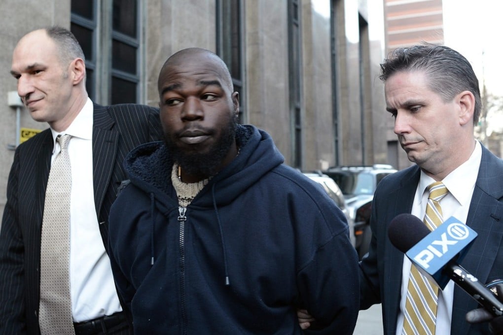 Naeem Davis (centre) is led into Manhattan Criminal Court by police in New York on December 5, 2012. Davis was found to have been defending himself when he pushed Ki-suck Han into the path of an oncoming subway train. Photo: EPA
