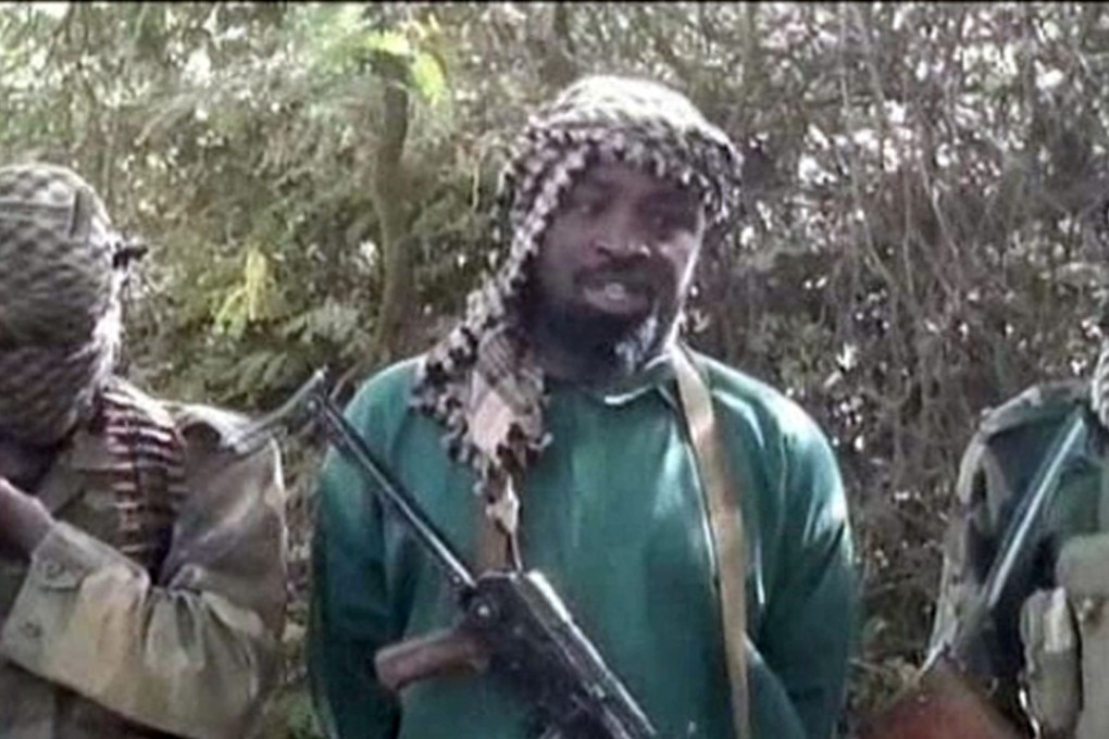 A picture taken from a video on March 5, 2013 shows Abubakar Shekau (centre), the suspected leader of Nigerian Islamist extremist group Boko Haram, flanked by two armed and hooded fighters in an undisclosed place. Photo: AFP