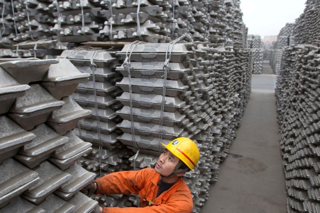 An employee checks aluminium ingots for export at the Qingdao Port in Shandong province. Photo: Reuters