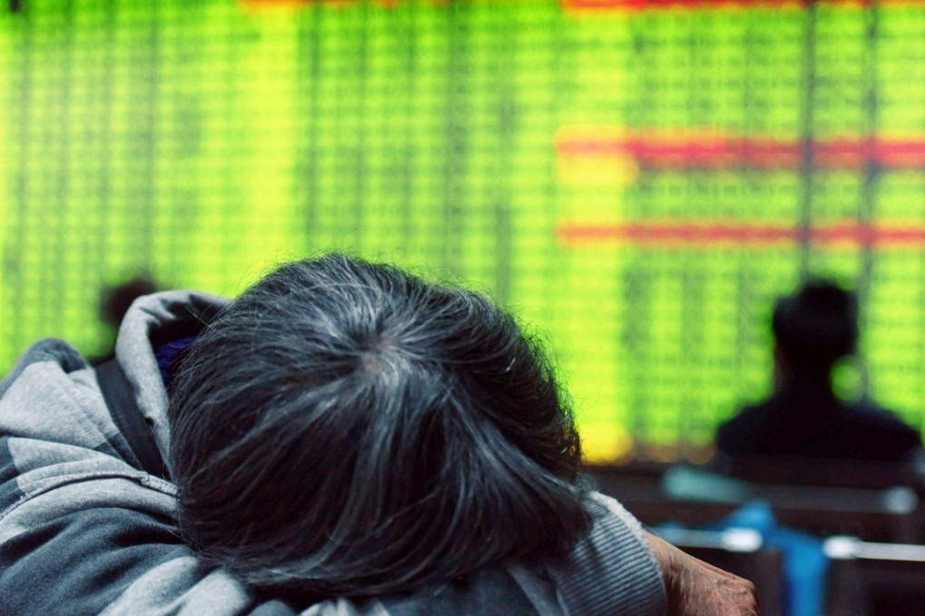 An investor taking a break in front of a screens showing stock market movements at a securities firm in Hangzhou. Contrary to global conventions, China’s stock market denotes positive gains in red, and declines and losses in green.Photo: AFP