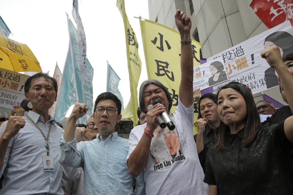 Pro-democracy Hong Kong lawmakers of the legislature council, Edward Yiu, Nathan Law, Leung Kwok-hung and Lau Siu-lai protest outside the High Court in Hong Kong, Friday, July 14, 2017. The four lawmakers were disqualified by court as they failed to take their oaths correctly in last year's elections during the day of the initial Legislative Council swearing-in ceremony. Photo: AP