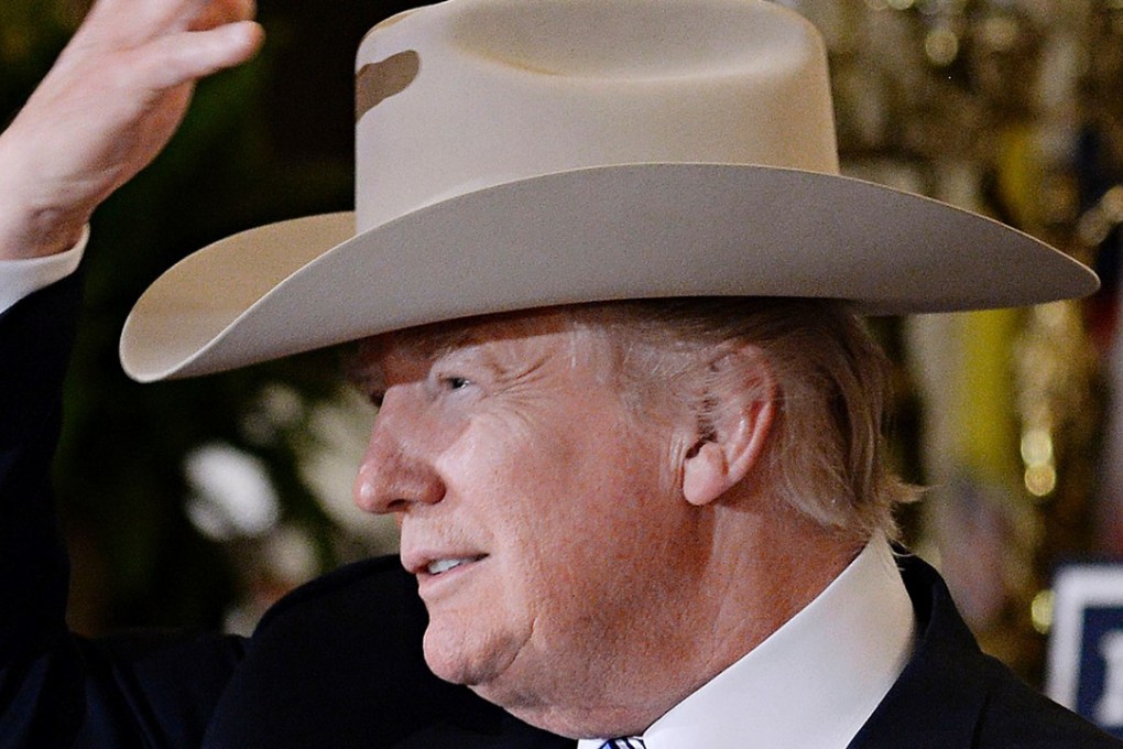 President Donald Trump examines US-made products from all 50 states, including a Stetson hat, as he denounced the failure to pass a bill in the Senate repealing ‘Obamacare’ . Photo: AFP