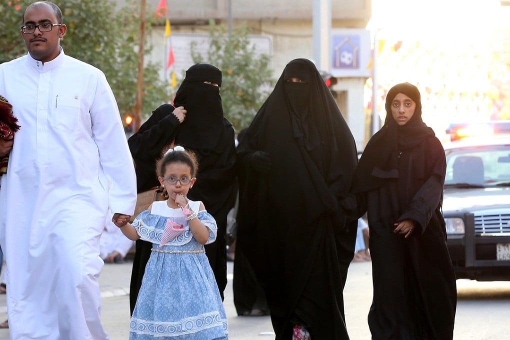 Saudi women and children walk after celebrating Eid al-Fitr prayers, in the courtyard of a mosque Prince Turki bin Abdul Aziz in Riyadh, Saudi Arabia. The three adult women are wearing black ‘abayas’ in public. Photo: EPA