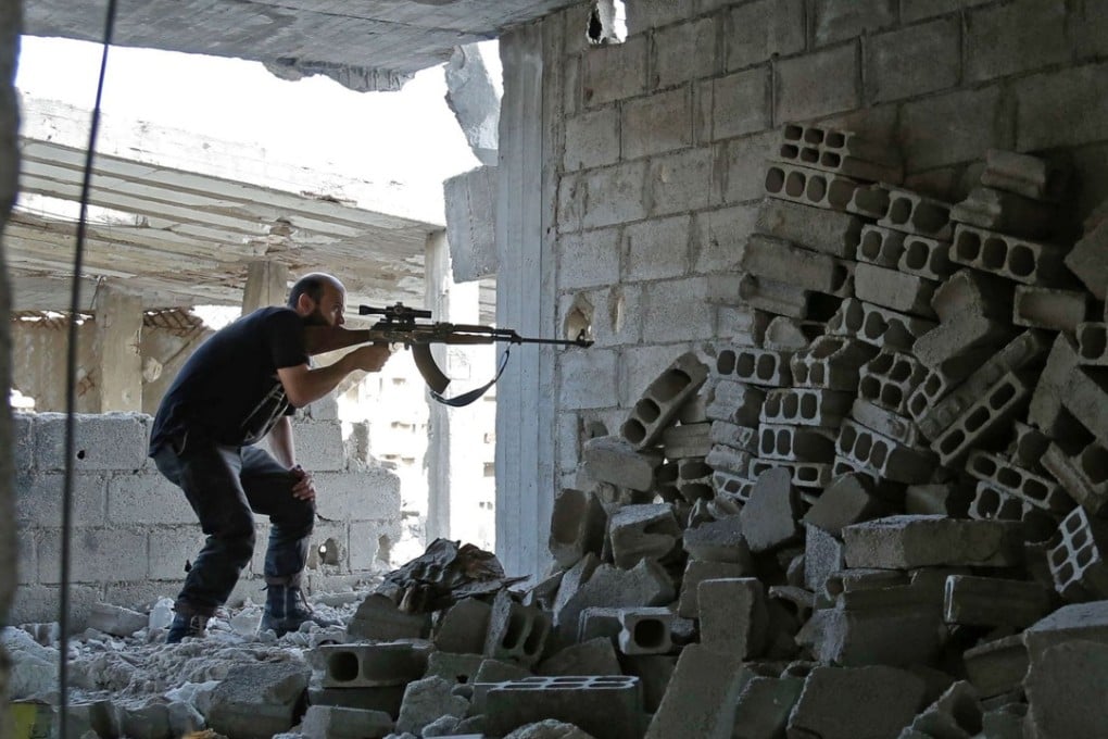 A Syrian rebel fighter fires a weapon in Ain Tarma, in the eastern Ghouta area, a rebel stronghold east of the capital Damascus, on Monday. Photo: AFP