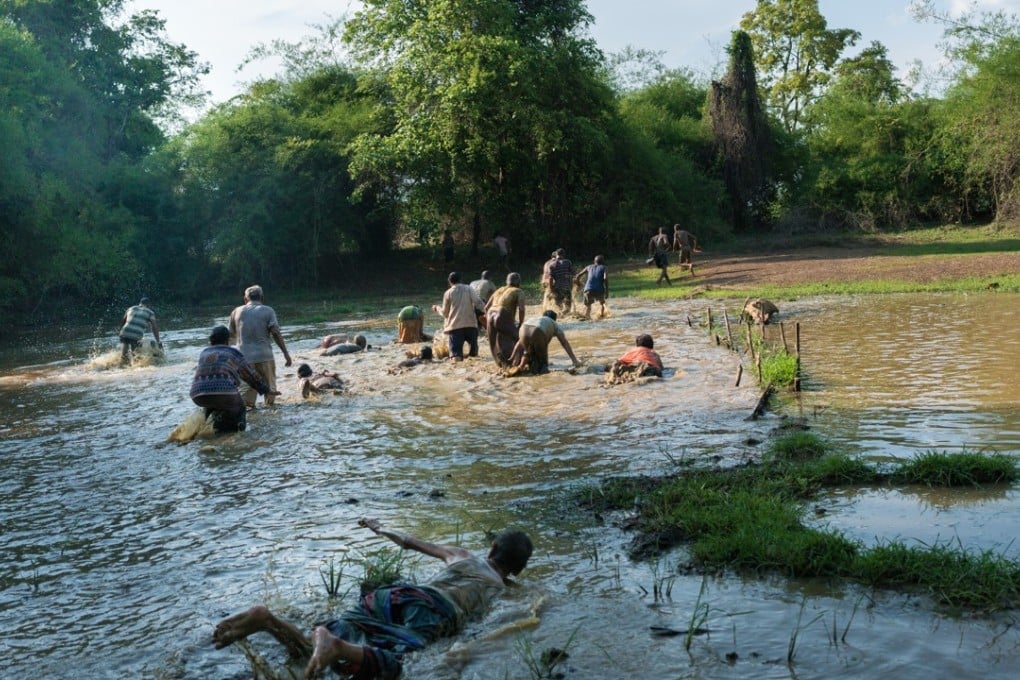 As part of a ritual to draw out the evil spirit known as Phi Pob, those accused of being possessed must crawl through a pond and cover themselves in mud before bathing in the Mekong. Pictures: Thomas Cristofoletti