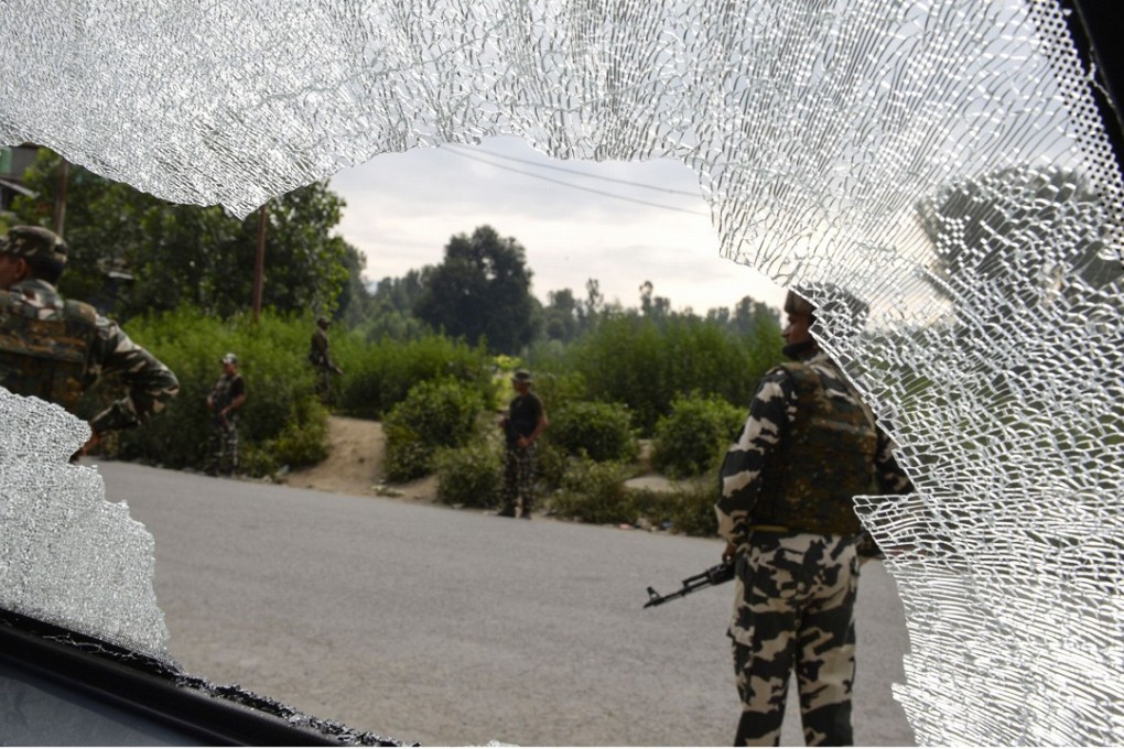 Indian paramilitary troopers are seen through the broken windshield of a vehicle at the site of an attack on Hindu pilgrims in Anantnag, south of Srinagar. Photo: AFP