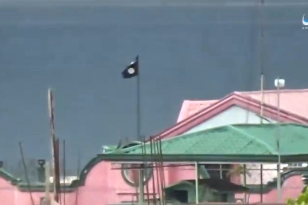 A still image taken from a video posted on social media of an Islamic State flag on building in Marawi. Photo: Reuters
