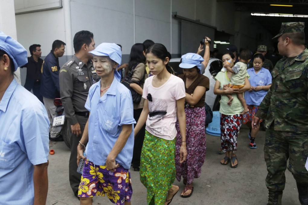 Myanmese workers are escorted by soldiers and police officers as they leave a shrimp shed after a raid conducted by Thailand's Department of Special Investigation in Samut Sakhon, Thailand. Photo: AP Photo