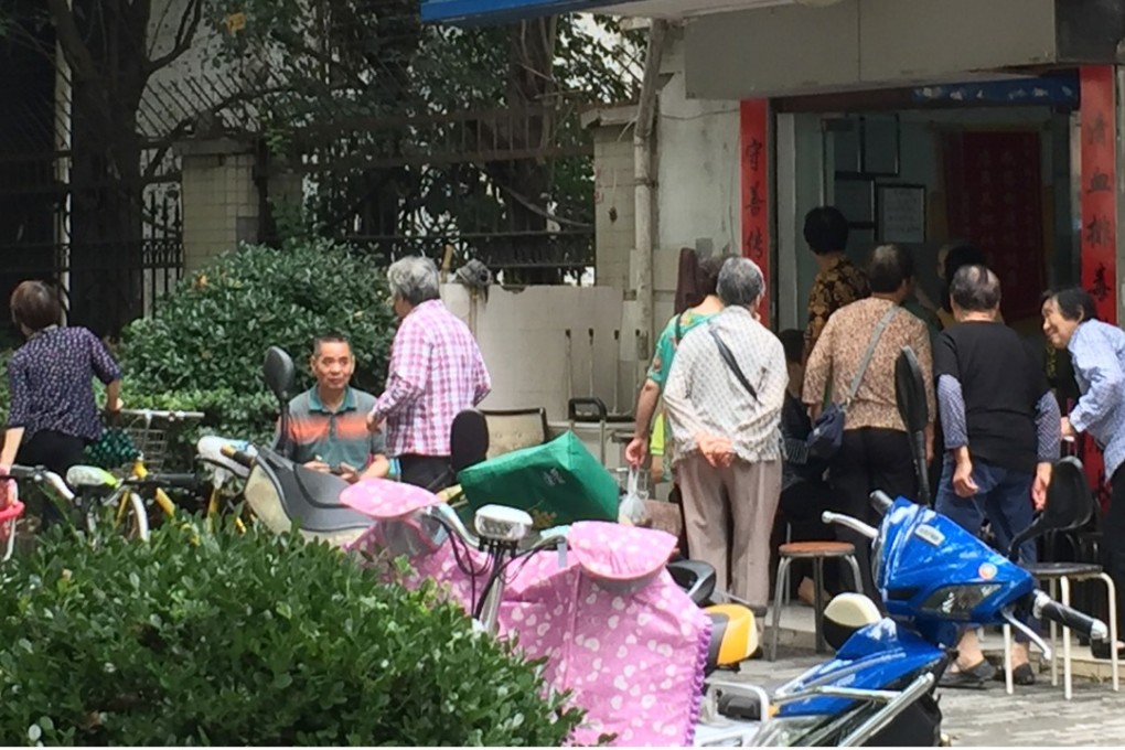 Senior citizens gather outside a health club in Shanghai, waiting to receive free treatment in an electrical “curing chair”. Photo: Alice Yan