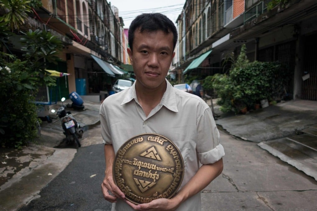 Thai dissident Ekachai Hongkangwan holds a brass replica of the missing plaque commemorating the year Thailand went from being an absolute monarchy to a democracy in 1932. Photo: AFP