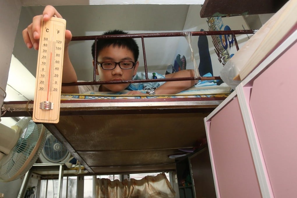 Wong Chak-ming, 13, draws attention to the hot, suffocating conditions in his partitioned home in Sham Shui Po, on July 2. Photo: David Wong