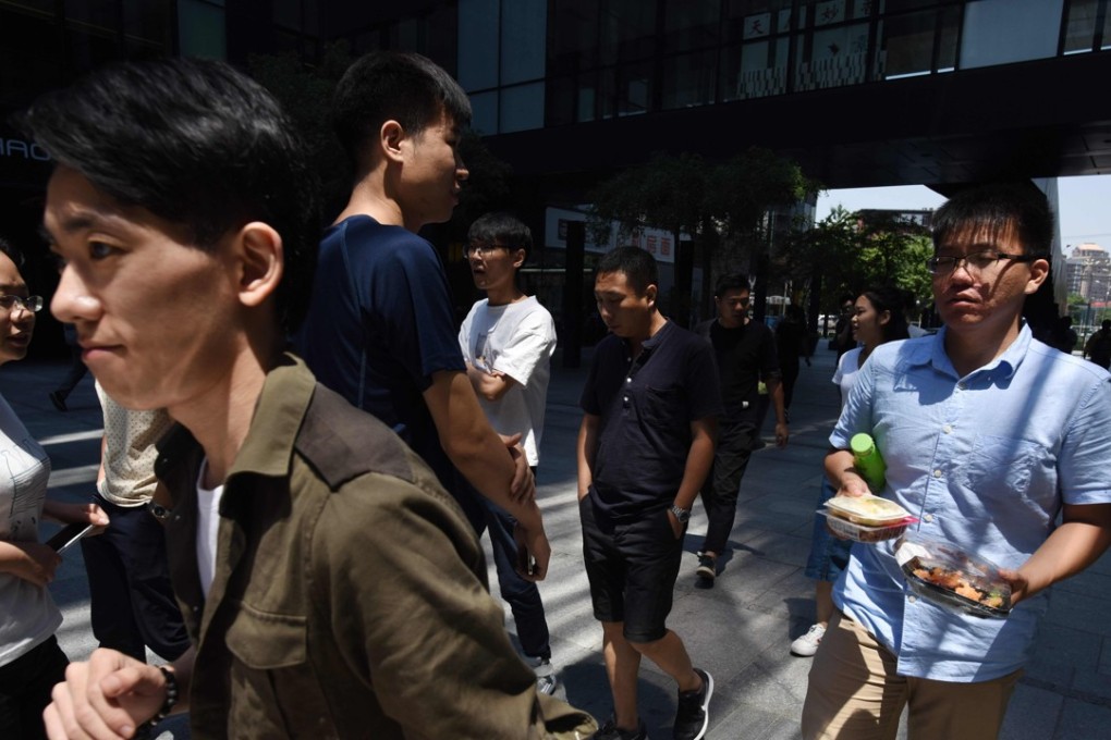 People walking outside an office building in Beijing . Photo: AFP