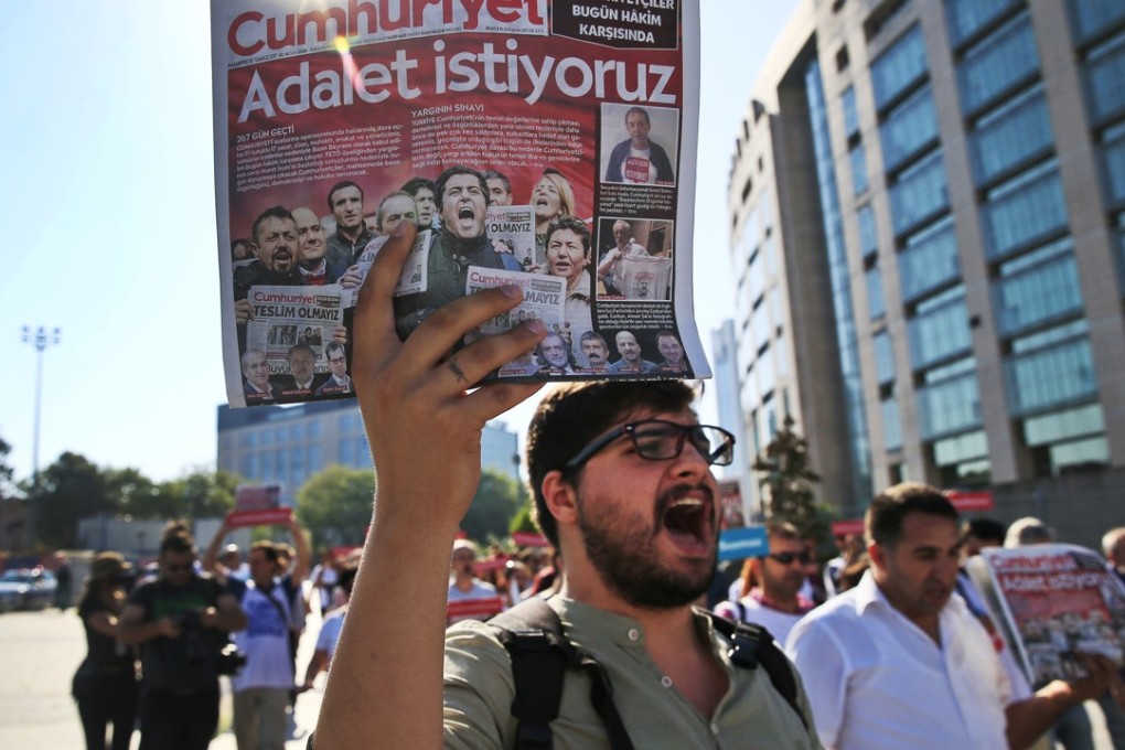 Protesters hold copies of the Cumhuriyet newspaper during a march to the court in Istanbul where the trial of journalists and staff accused of aiding terror organisations started. Photo: AP