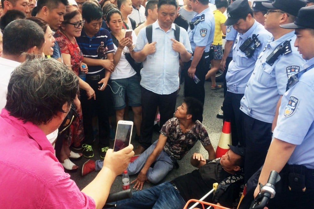 People trying to join a protest against a fraudulent investment scheme in Beijing on Monday lie on the ground after being blocked by police. Photo: Kyodo