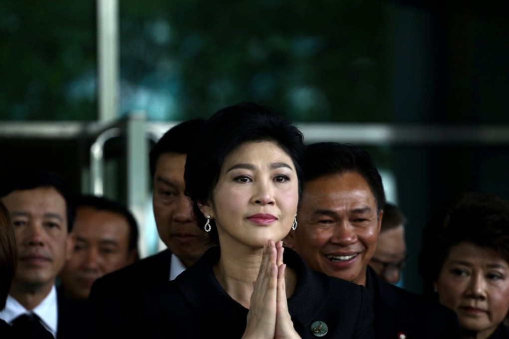 Ousted former Thai prime minister Yingluck Shinawatra greets supporters as she arrives at the Supreme Court in Bangkok. Photo:Reuters