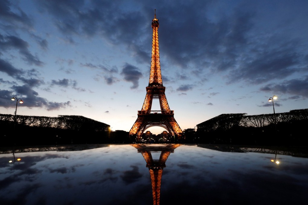 A night view shows the Eiffel tower, reflected on a car's roof, in Paris, France. Photo: REUTERS/Christian Hartmann