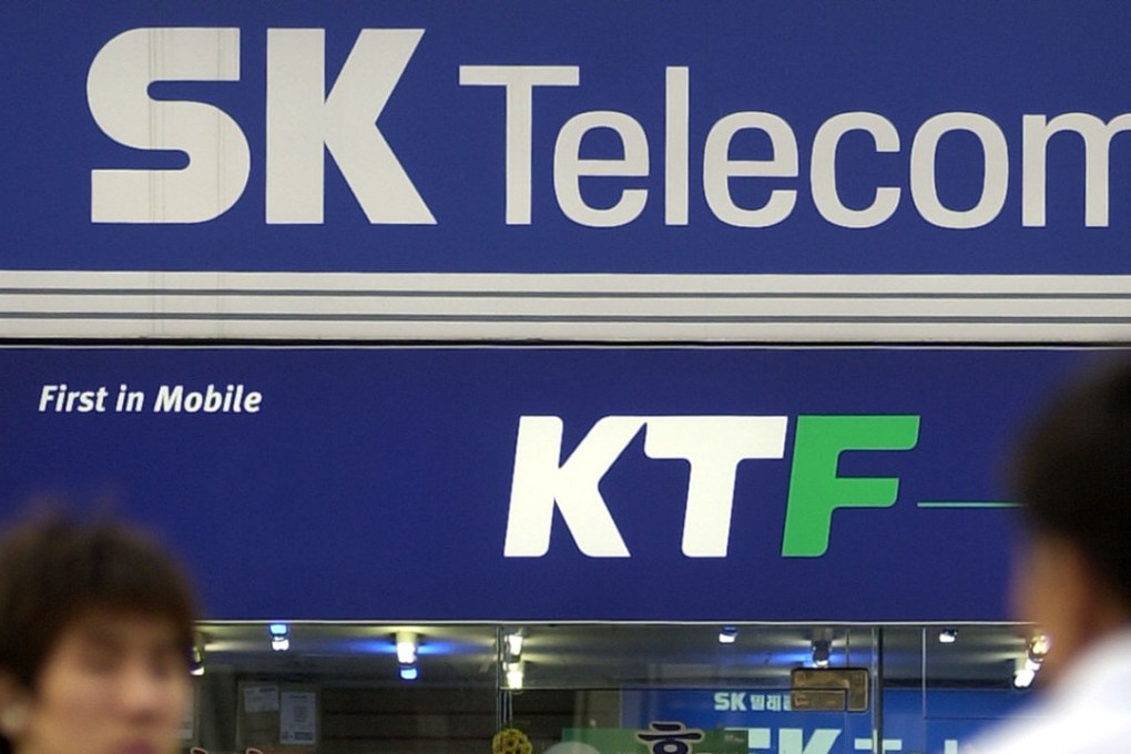 South Koreans cross in front of SK Telecom and KTF 's sign boards in Seoul. Photo: AFP/CHOI JAE-KU