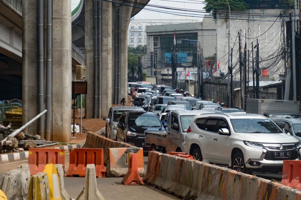 Vehicles pack a narrow road next to an under-construction flyover in Jakarta. Photo: AFP
