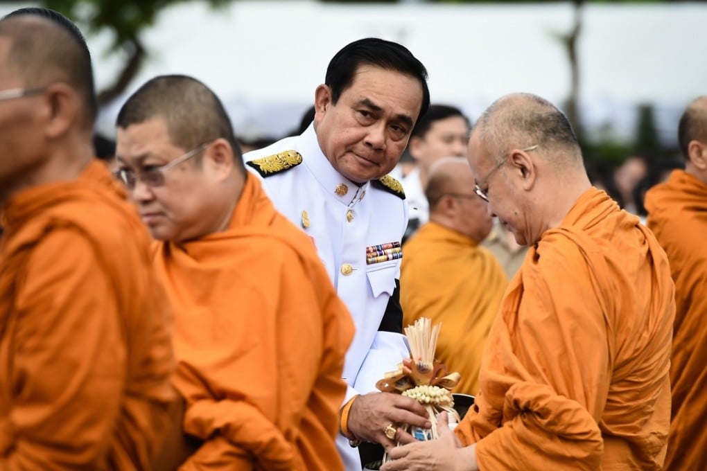 Thai Prime Minister Prayuth Chan-ocha gives alms to Buddhist monks to celebrate the birthday of King Maha Vajiralongkorn. Photo: AFP