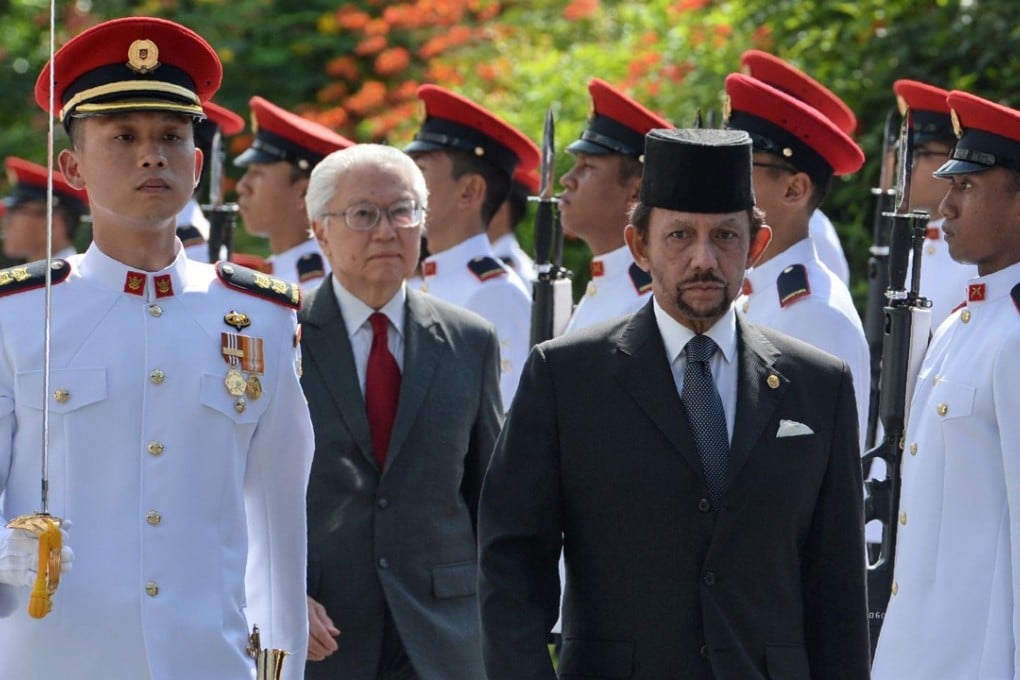 Sultan of Brunei Hassanal Bolkiah, front right, is accompanied by Singapore's President Tony Tan Keng Yam as they inspect an honour guard during his welcoming ceremony at the Istana presidential palace in Singapore. Photo: AFP