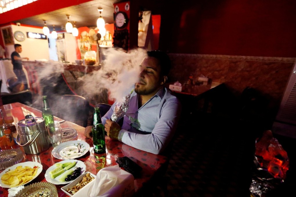 A man drinks and smokes a shisha at a bar in the town of Qaraqosh, south of Mosul. Photo: Reuters