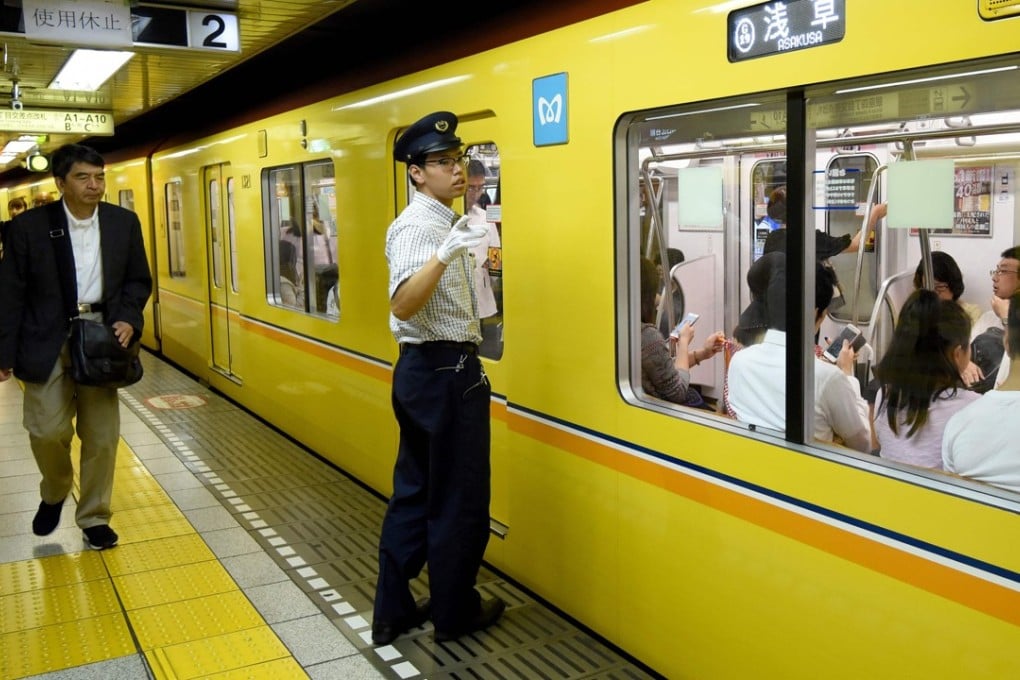 A station attendant at a platform on the Tokyo subway, where priority seats can remain free even during rush hour. Photo: AFP