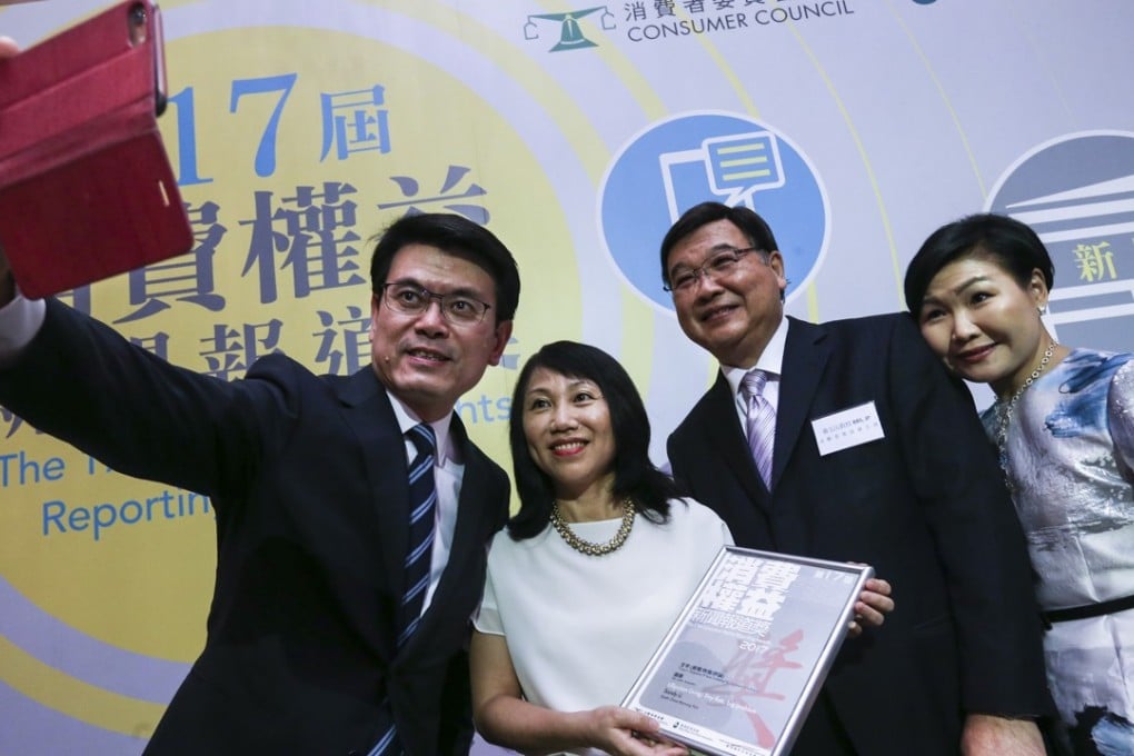 No small feat ... the South China Morning Post’s property editor Sandy Li Chau-wa poses for a selfie with Secretary for Commerce and Economic Development Edward Yau Tang-wah (left) and the Consumer Council’s chairman Wong Yuk-shan and chief executive Gilly Wong Fung-han after collecting the prize for her article “Lilliputian living”. The report on proposed flats with living space of just 50 sq ft won the silver award in the news, features and commentaries category of the Consumer Council’s 17th Consumer Rights Reporting Award. There were more than 200 entries in the competition this year. Photo: Dickson Lee
