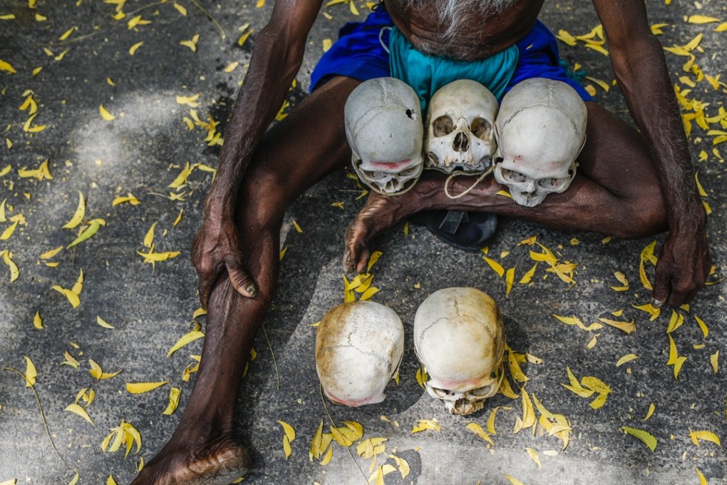 A farmer from the southern state of Tamil Nadu sits on the ground with the skulls of farmers who have committed suicide in their region. File photo: Bloomberg