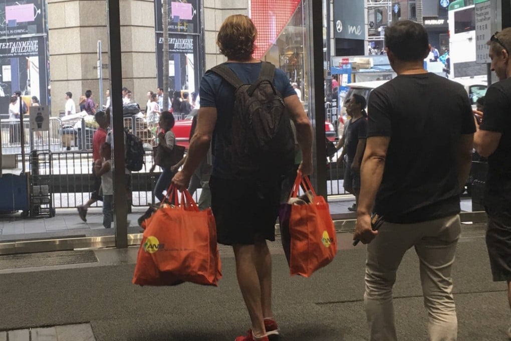 Members of Epic MMA Club leave its gym in Queen's Road, Central, carrying their belongings on Tuesday, a day after the club went into liquidation. Photo: Kylie Knott