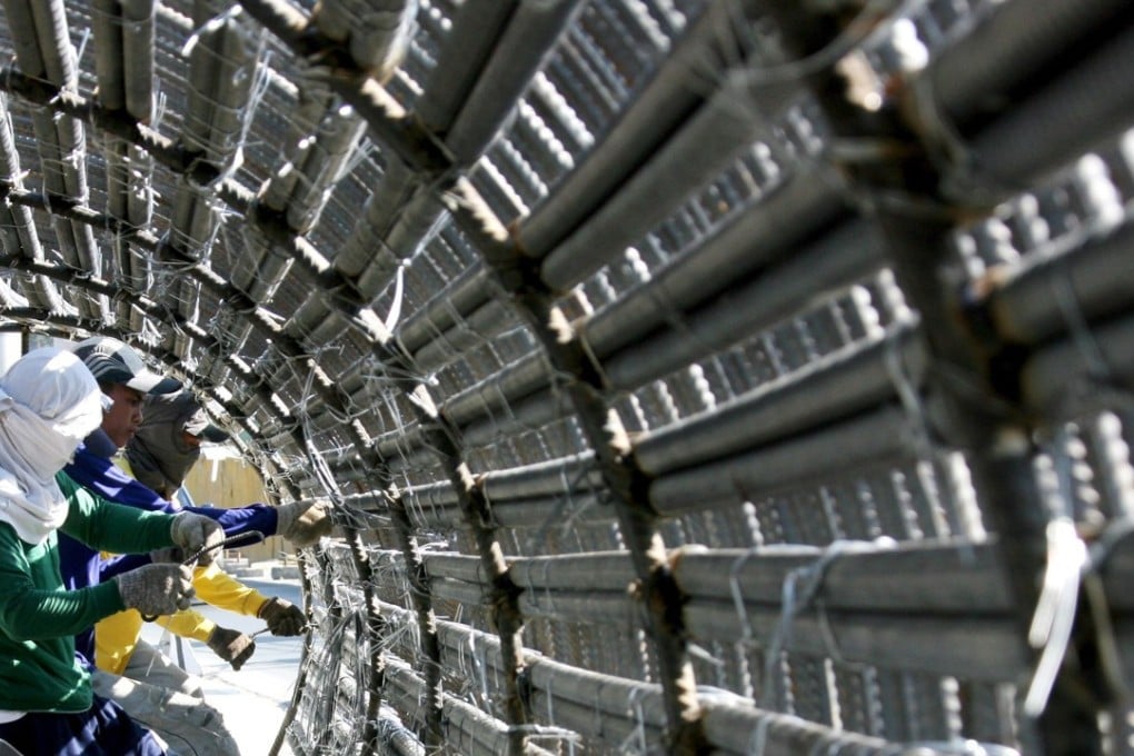 Filipino workers prepare the steel reinforcement bars for the construction of new highway flyover leading to Manila International airport in Manila suburbs. Until now the global construction industry has lacked a common language and framework for classifying and reporting construction costs, which has often caused huge problems for consultants, quantity surveyors, construction economists and cost engineers around the world. Photo: EPA