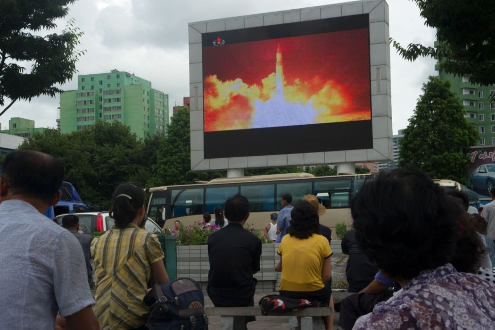 People watch as coverage of a North Korean intercontinental ballistic missile test is displayed on a screen in a public square in Pyongyang, on July 29. Photo: AFP