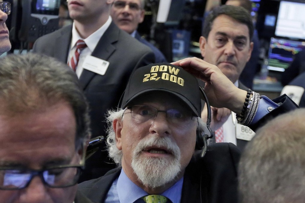 Trader Peter Tuchman, centre, wears a "Dow 22,000" hat as he works on the floor of the New York Stock Exchange, on Wednesday, August 2, 2017. A rally in Apple shares powered the Dow Jones industrial average above 22,000 for the first time. Photo: AP