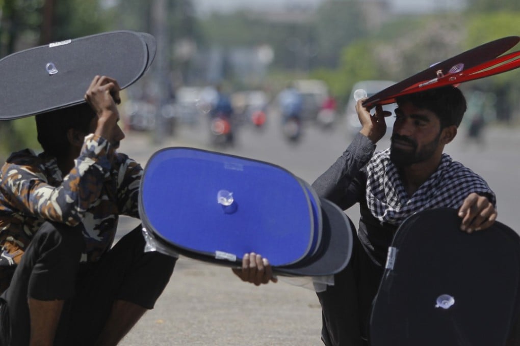 Indian vendors who sell sunshades for car windows rest by a roadside on a hot summer afternoon in Jammu, India. A new study suggests wide swaths of northern India, southern Pakistan and parts of Bangladesh may become so hot and humid by the end of the century it will be deadly just being outdoors. Photo: AP