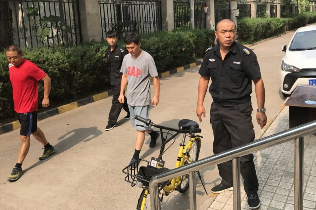Security guards stop journalists from entering Liu Xia’s apartment building on July 17. Photo: EPA