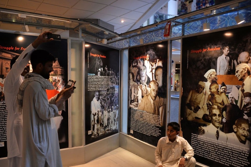 A Pakistani visitor takes a photograph in front of historical pictures of Hindu and Muslim leaders seeking independence from British rule. Photo: AFP