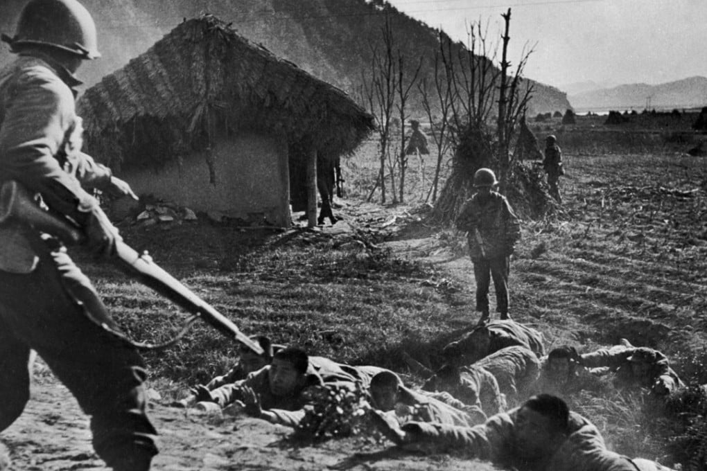 American soldiers order Chinese prisoners to the ground outside Seoul prior to the taking of the city by US and UN troops during the Korean war, in 1951. Picture: AFP