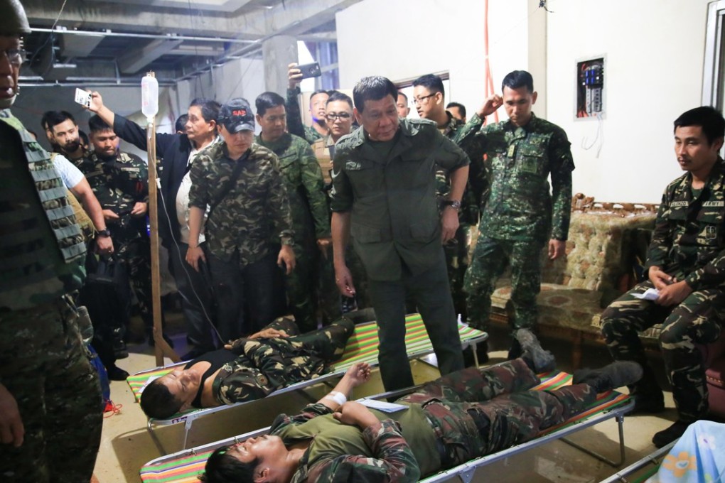 Philippine President Rodrigo Duterte checks on wounded soldiers during his visit at a military camp in in Marawi City. Photo: EPA