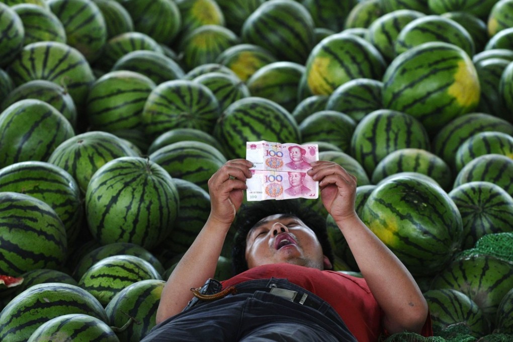 A watermelon vendor looks at his money in this file photo. People helping to harvest winter melons in south China can make up to US$60 a day, but it’s back-breaking work. Photo: Reuters