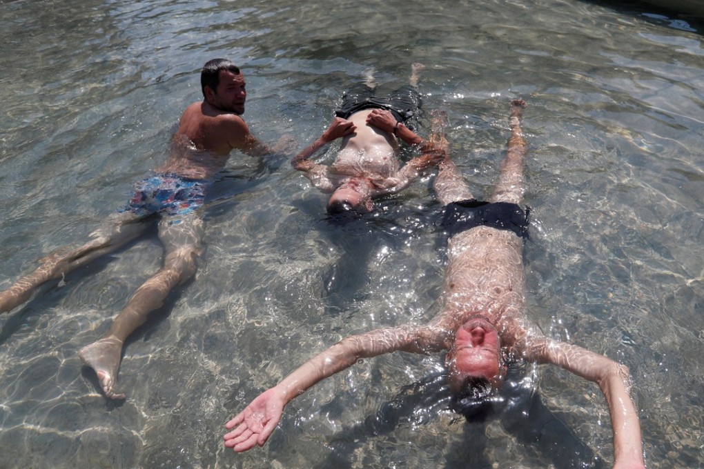 Men cool off in a fountain in Budapest, Hungary. Photo: Reuters