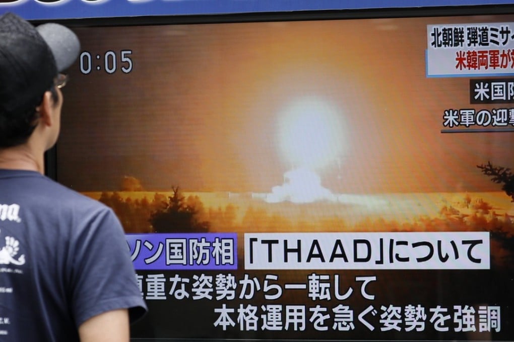 A pedestrian watches a public Japanese television news programme reporting on North Korea’s latest test-firing of an intercontinental ballistic missile. Photo: EPA