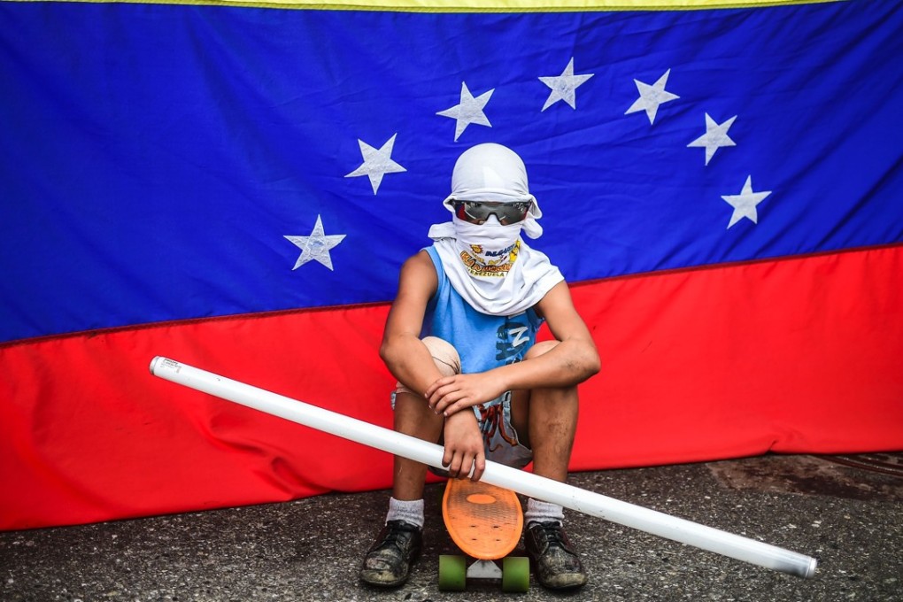 An opposition activist, not connected with the alleged attacks on the military base, stands by during a protest against the newly inaugurated Constituent Assembly in Caracas. Photo: AFP