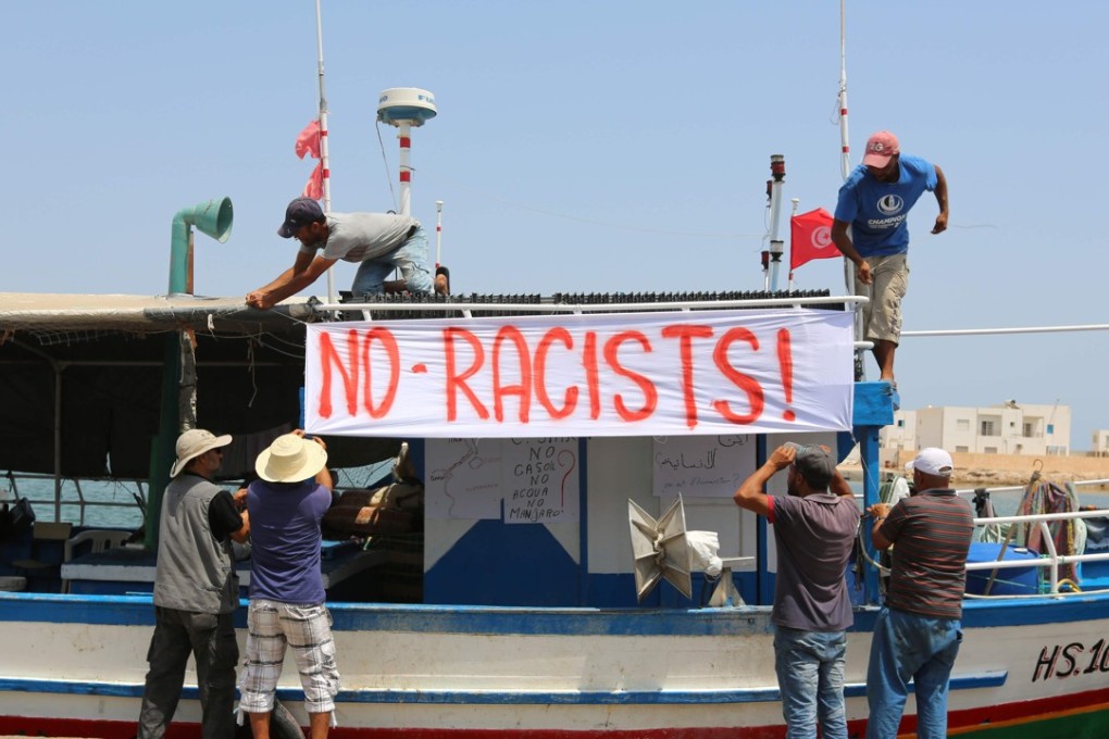 Tunisian fishermen hang banners as they gather on Sunday in the port of Zarzis in southeastern Tunisia to protest against a possible berthing of the C-Star vessel, hired by far-right activists. Photo: AFP